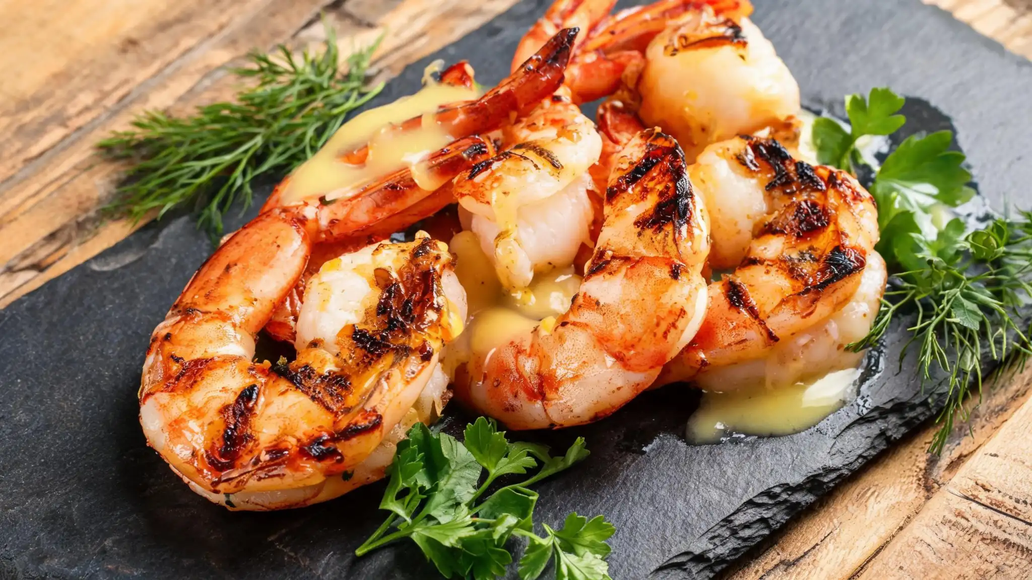 Fresh shrimp and salmon summer ingredients on a rustic cutting board